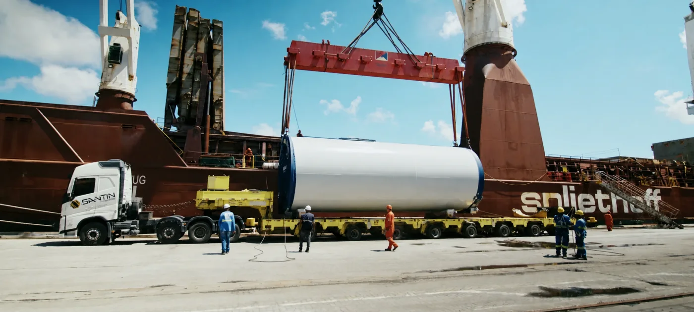 Operação portuária movimenta uma seção de torre eólica para o navio.